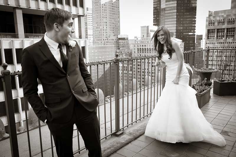 Destination wedding photographer Laurie Rhodes captures bride and groom in New York City on balcony overlooking the skyscrapers of midtown Manhattan